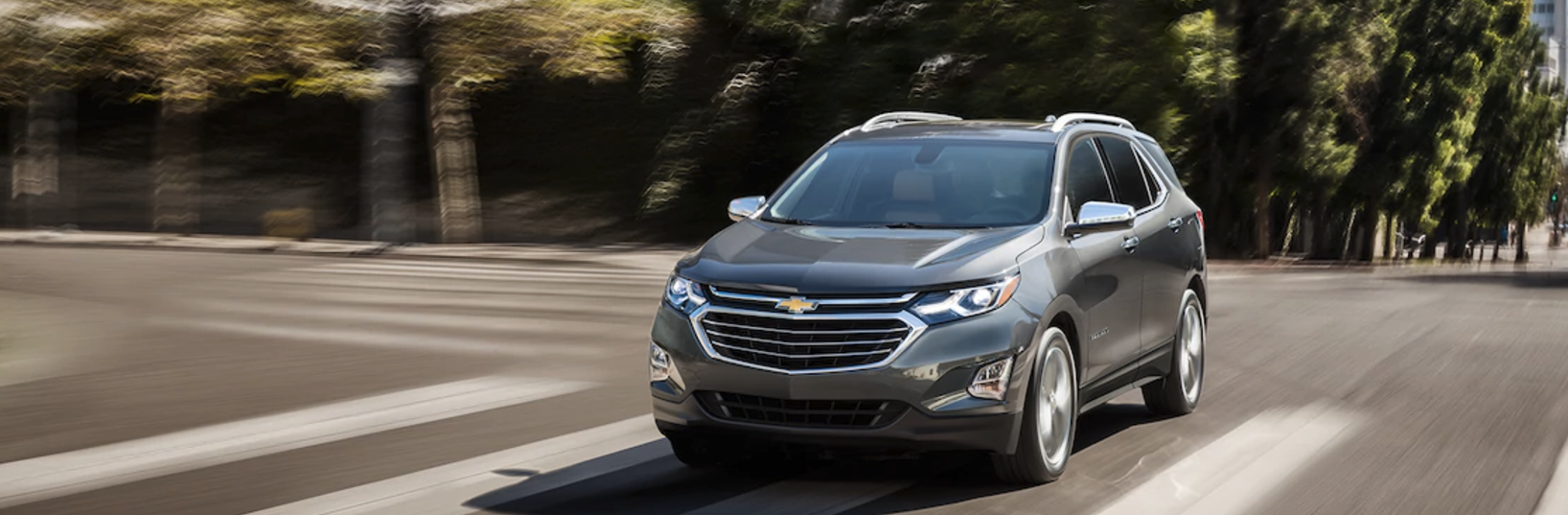 A gray 2018 Chevy Equinox driving down the street.